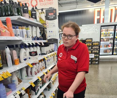 Sally wearing a Coles shirt in a shopping aisle