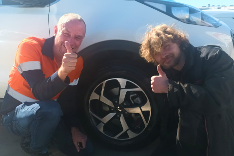 Zak and Josh by a tire doing thumbs up